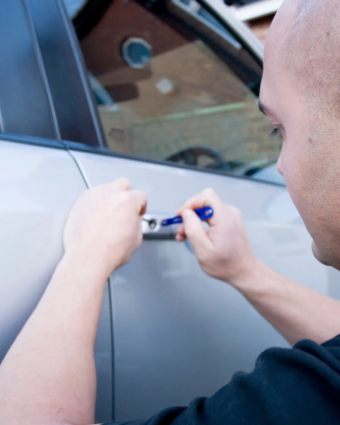 Locksmith picking a car door lock with a pick tool, automotive locksmith service Port St. Lucie