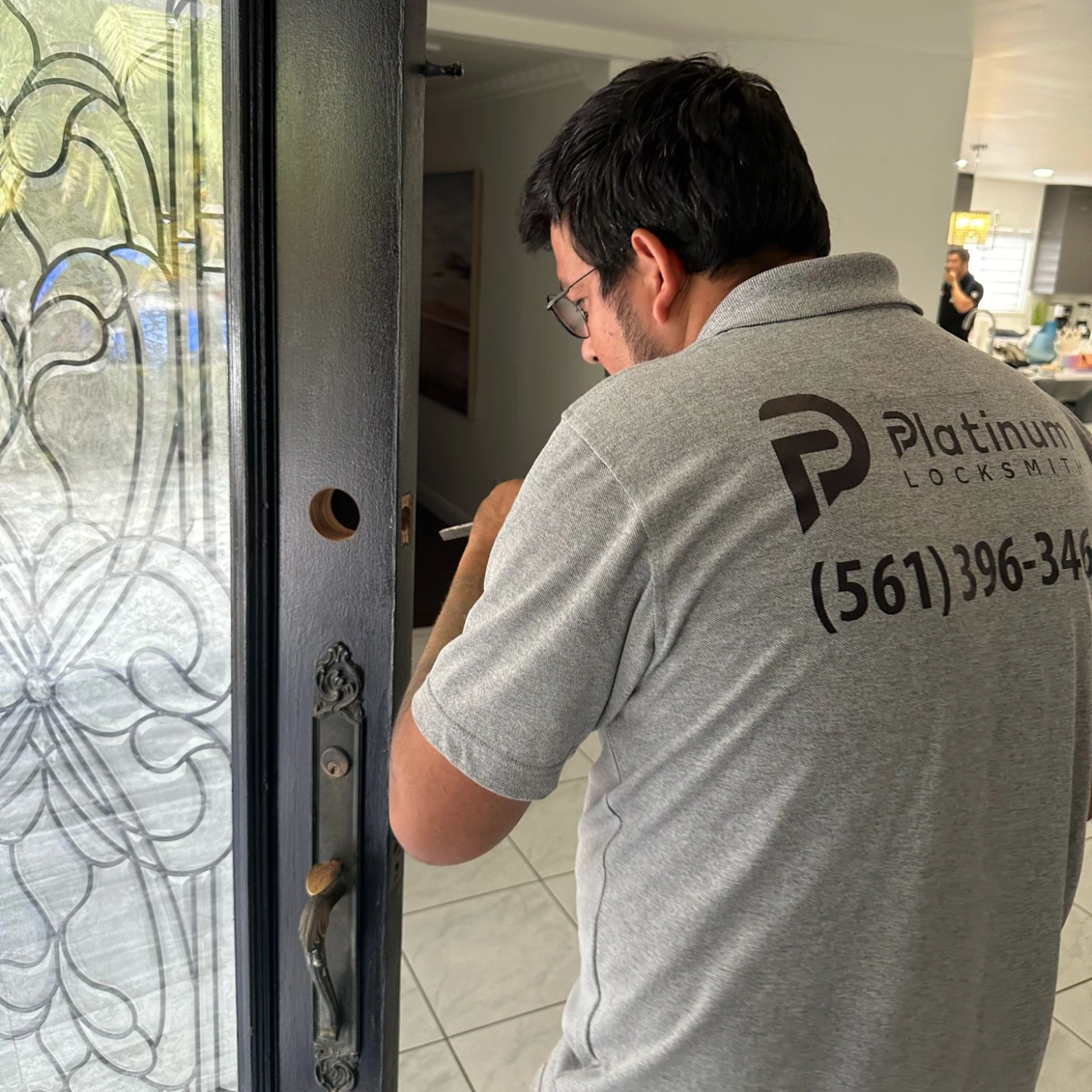 Locksmith Moab installing a deadbolt on a black residential front door, residential locksmith service