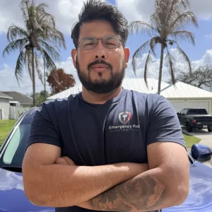Moab, the licensed locksmith and owner of Emergency Pro Locksmith, smiling in front of his branded service van in Florida